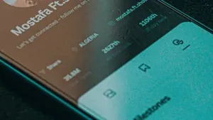 A smartphone on a dark surface showing a music app open on screen