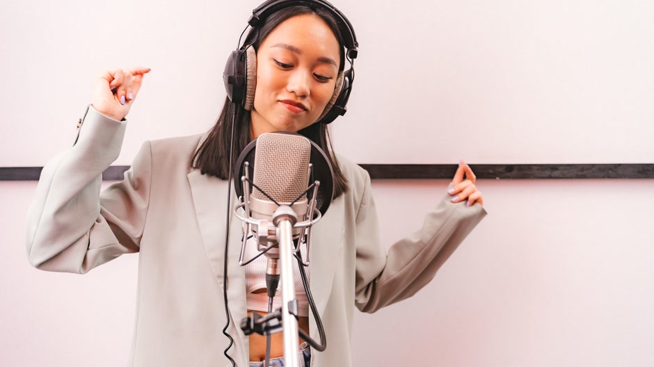 Vocalist recording a take in a studio booth