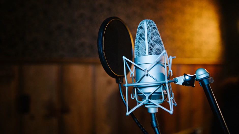 A condenser microphone in a dark studio, ready for a recording session