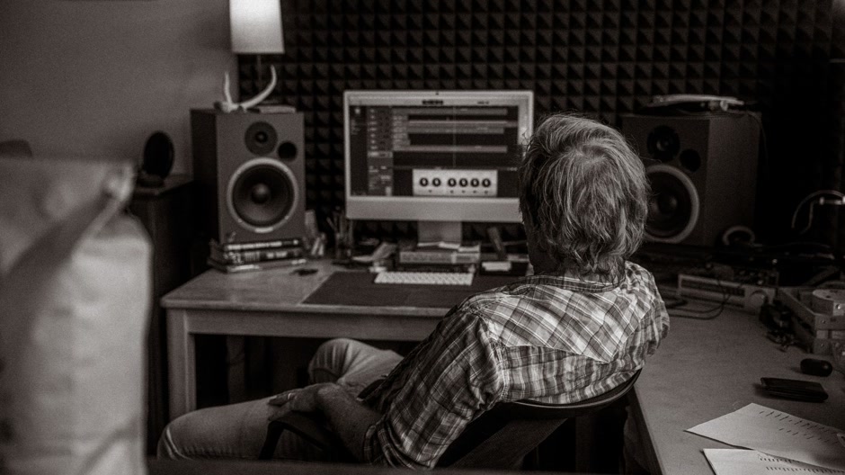 Producer checking meters while working on a master in a studio