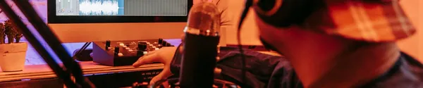 A producer working on a laptop at a desk in a studio