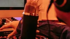 A producer working on a laptop at a desk in a studio