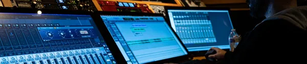 Producer working at a DAW in a dark studio, the kind of session an AI beat cannot fake