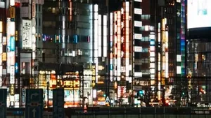 Shinjuku street at night seen from above, neon signs and traffic