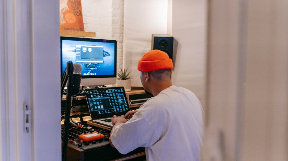 Producer working on a song in a dark home studio