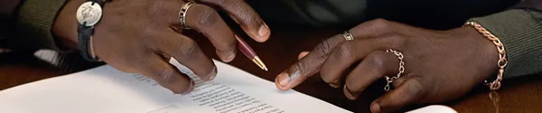 Close up of a producer holding a pen over a licensing contract