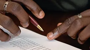 Close up of a producer holding a pen over a licensing contract