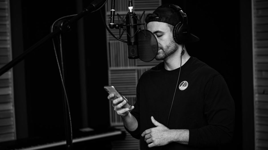A musician checking a beat in a dark studio