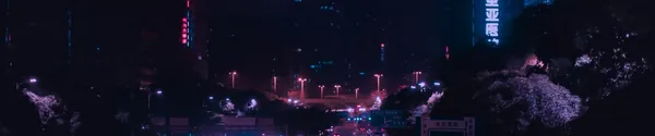 Car lights streaking through a dark street at night